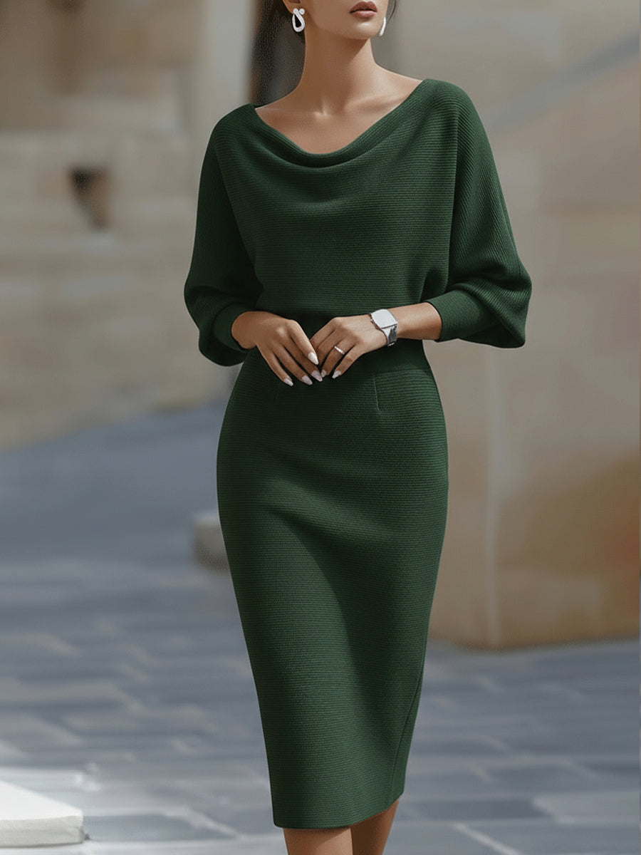 Woman wearing a white batwing sleeve midi dress with pencil skirt on a plain background.