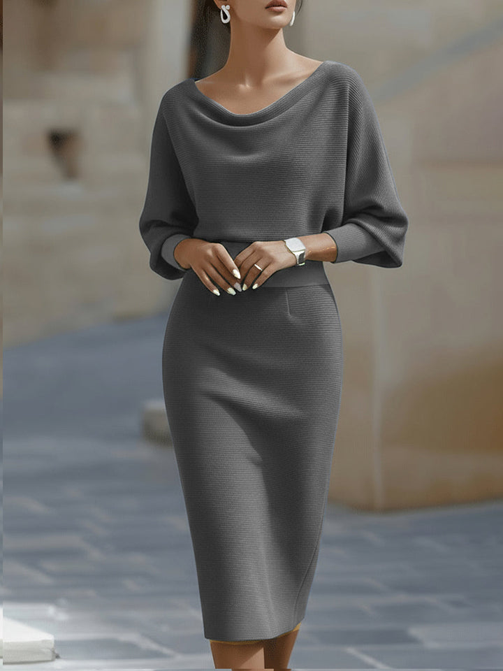 Female model in a white midi pencil dress with draped bodice on a plain background.