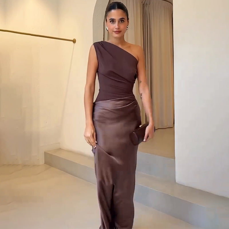 Female wearing a flowing maxi dress on a plain background.