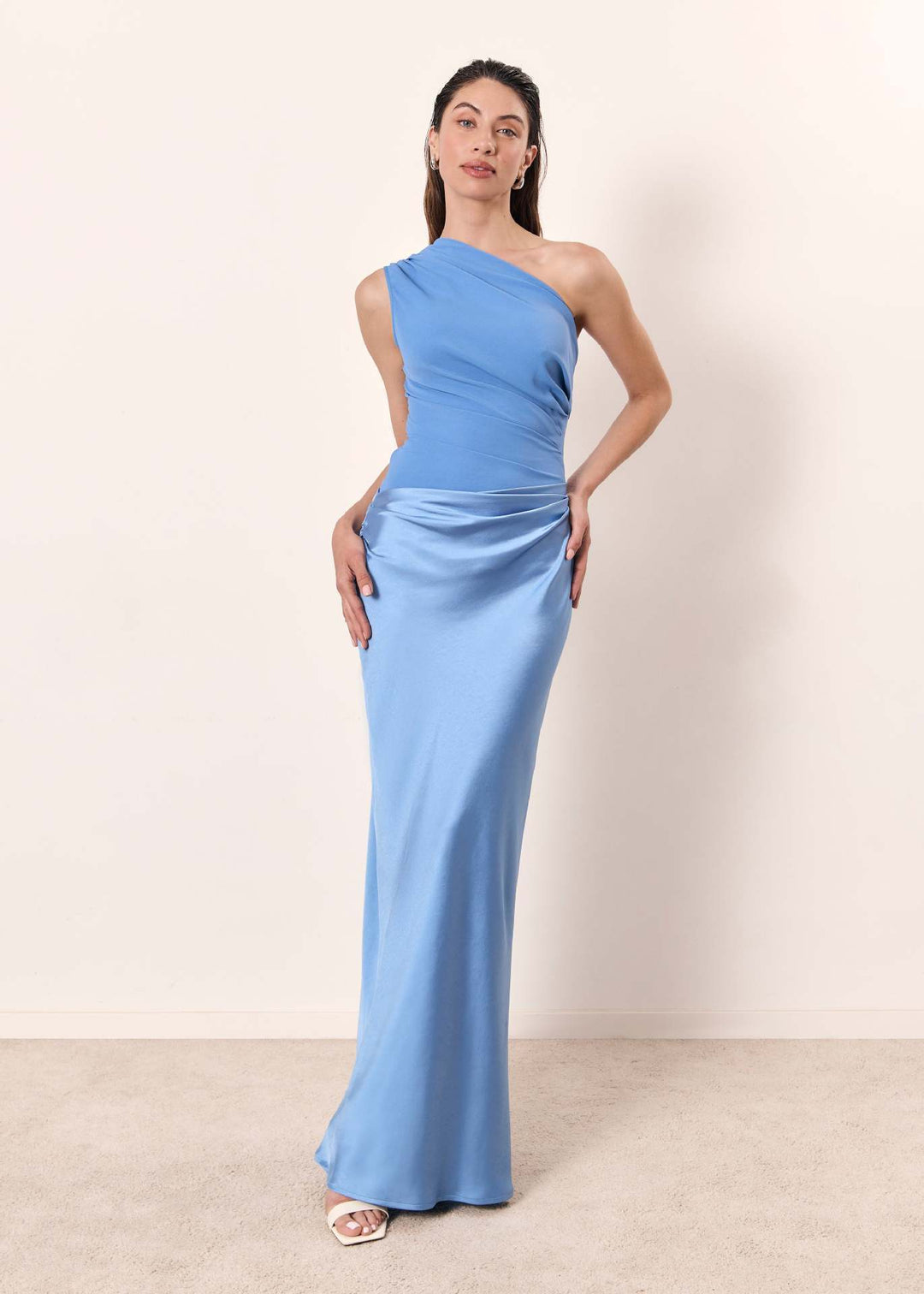 Woman in a stylish maxi dress designed for spring and summer occasions on a plain background.