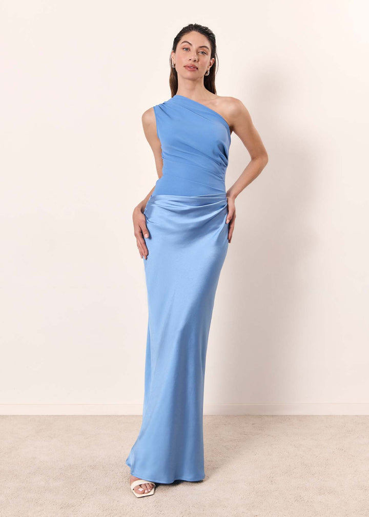 Woman in a stylish maxi dress designed for spring and summer occasions on a plain background.