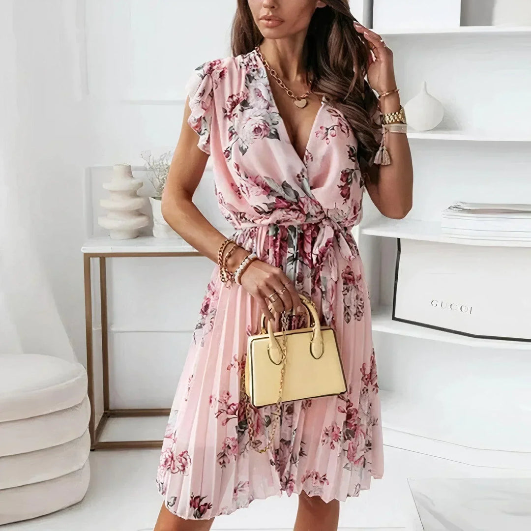 Female model wearing a floral midi dress with a V-neck and flutter sleeves against a plain background.
