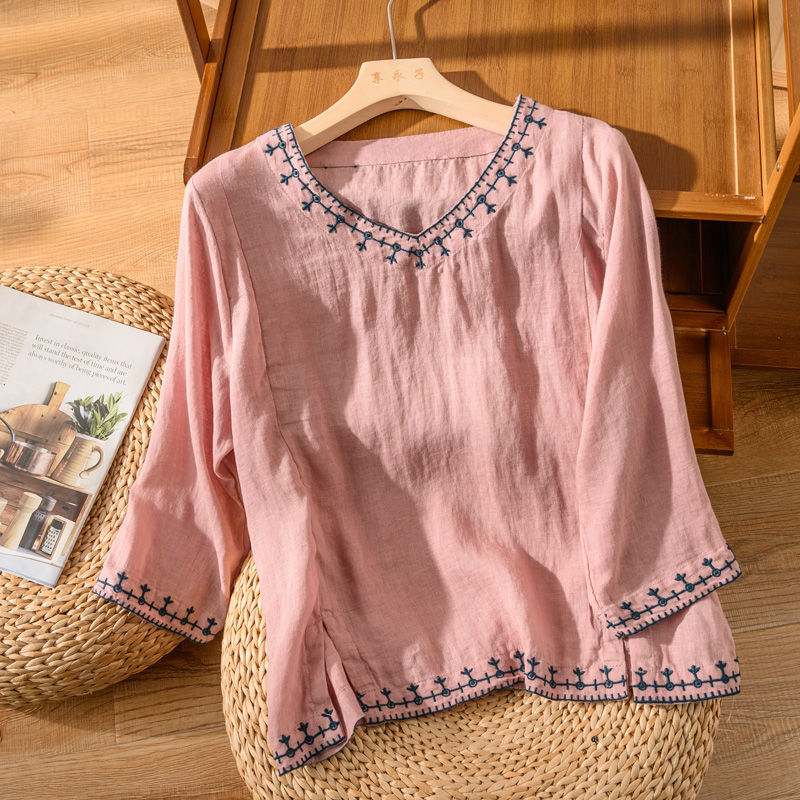 Lightweight embroidered blouse displayed on a nature furniture background with refined style.