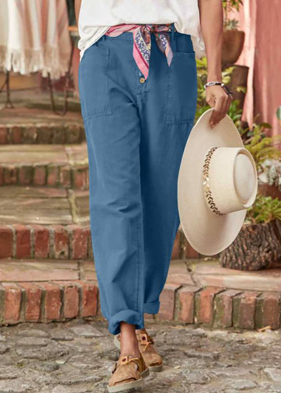 Woman in softly tailored trousers standing on a staircase background.