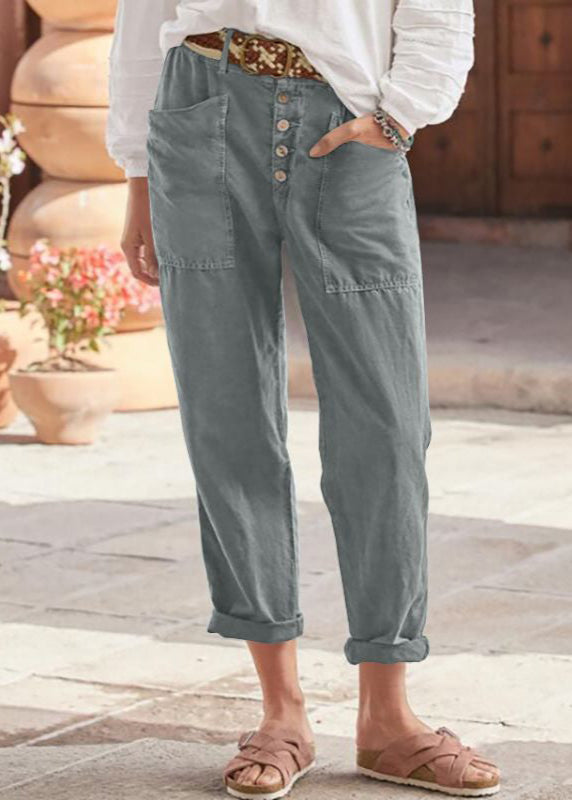 Woman posing in elegant wide leg trousers with plain background.