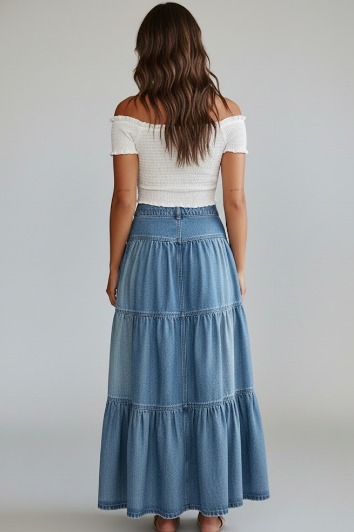 Woman in tiered maxi denim skirt and white top back display