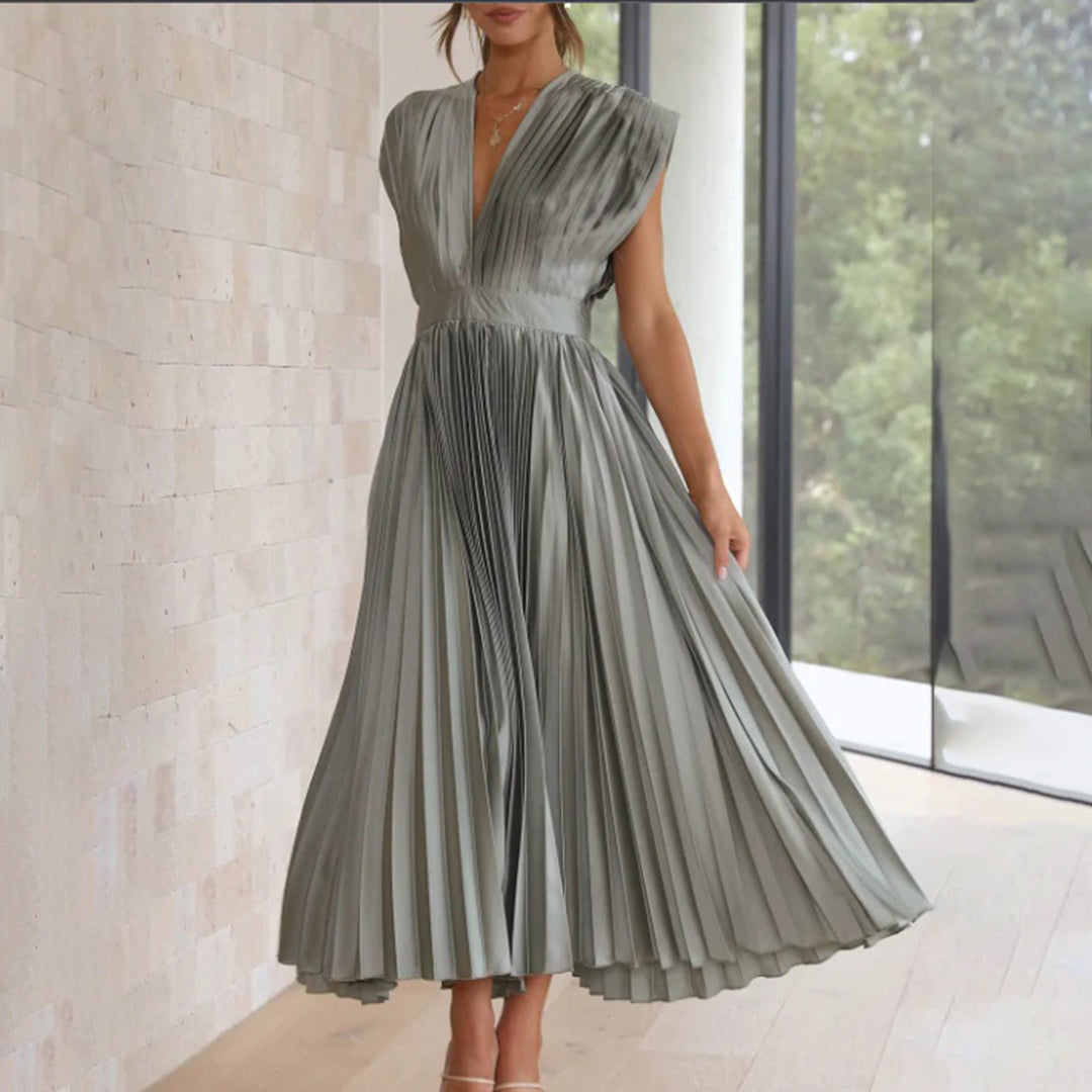 Model wearing a classy dress against a plain background.