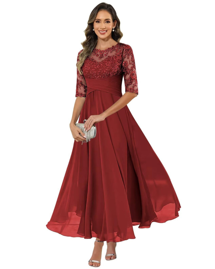 Female model wearing a flowing formal dress on a plain background.