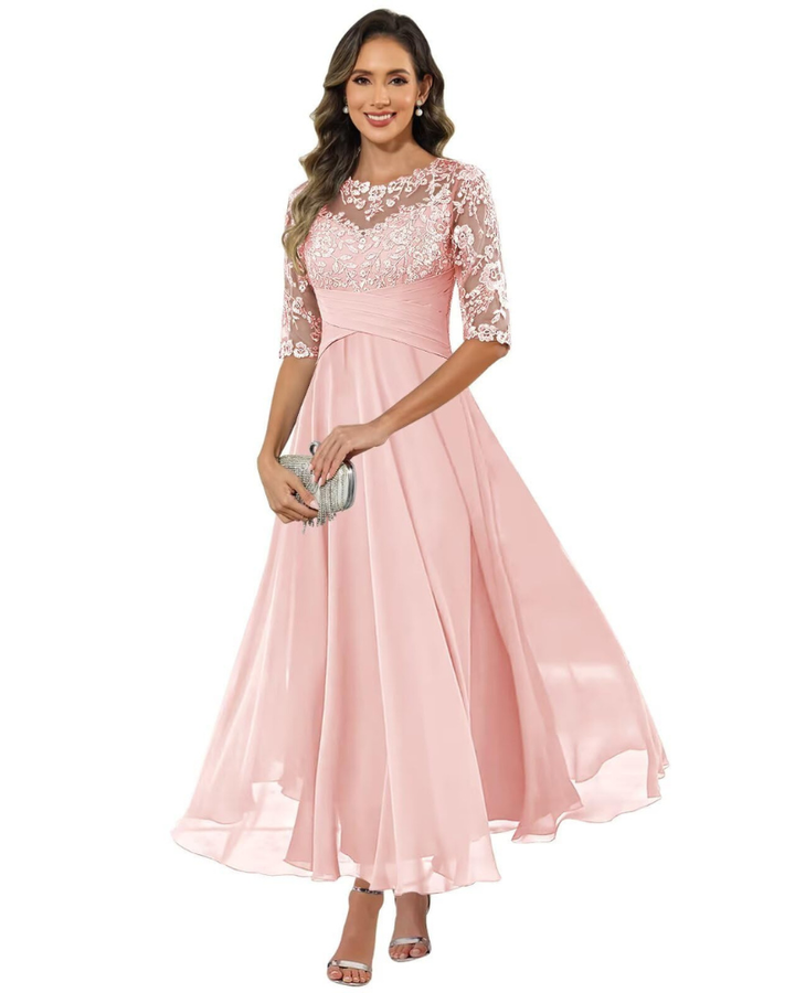 Female model displaying a long celebration dress on a plain background.