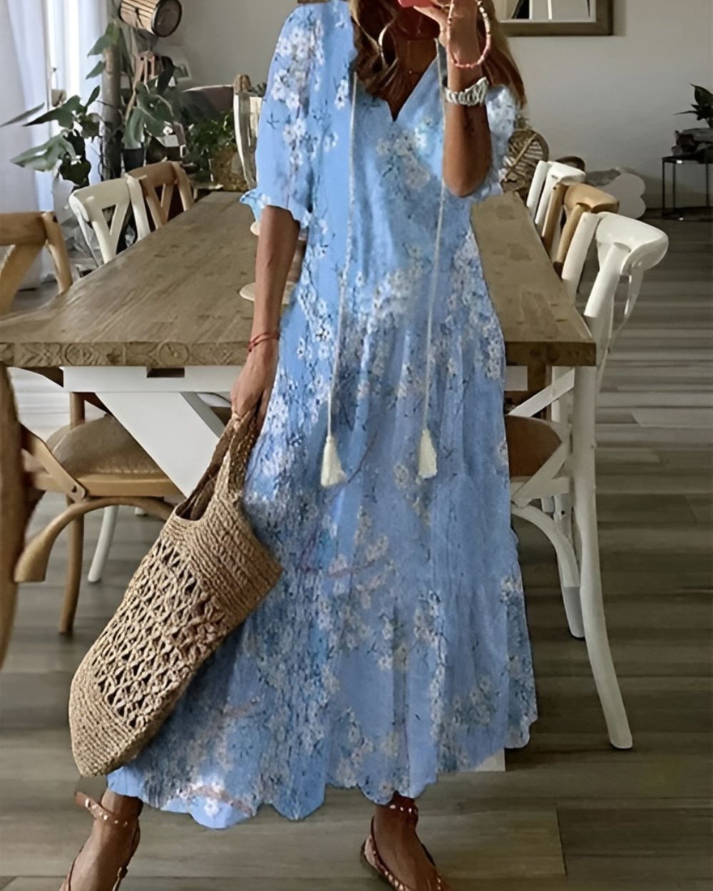 Woman wearing a lightweight boho-inspired dress in a studio setting with plain background.
