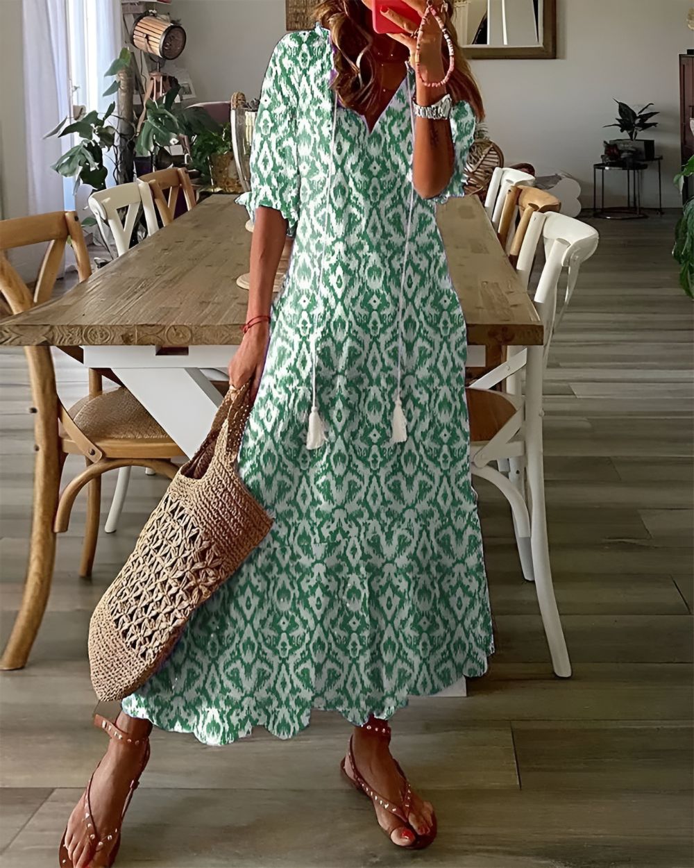 Woman posing in a loose-fit patterned dress on a plain background.