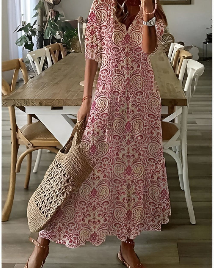 Female model in an airy casual dress featuring a relaxed silhouette on a plain background.