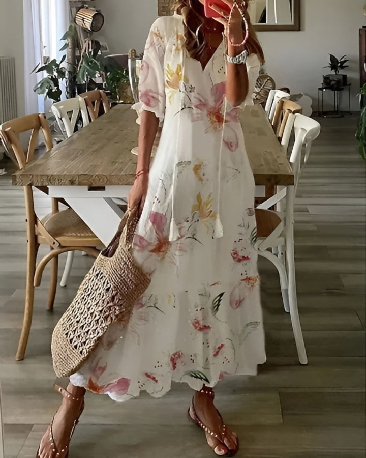 Woman modeling a breezy vacation-style dress against a plain background.