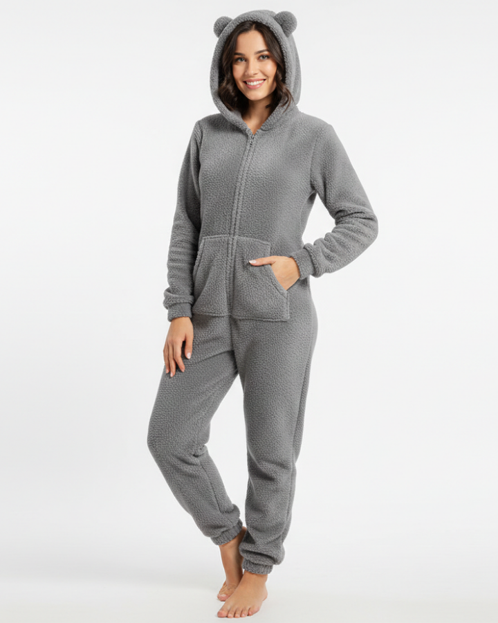  Woman wearing a warm hooded jumpsuit with a casual silhouette against a plain background.