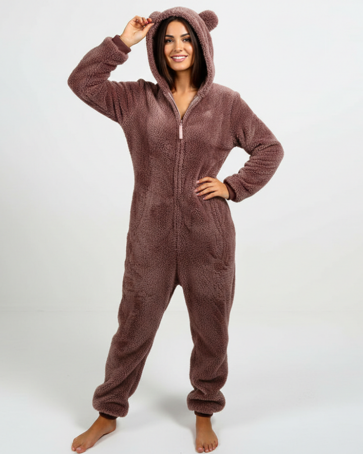  Woman showcasing a cozy one-piece fleece outfit with a hood on a plain background.