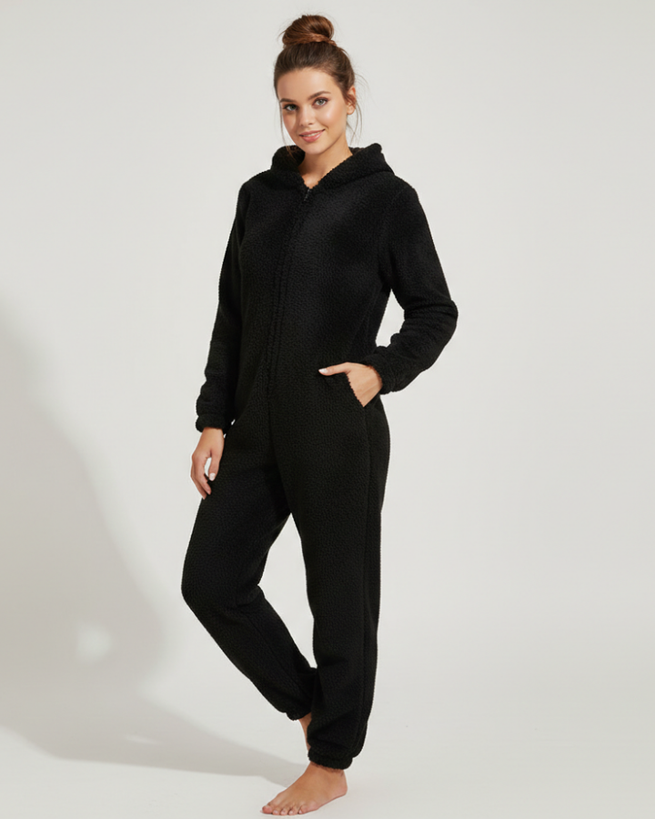  Female model displaying a zip-up fleece one-piece outfit on a plain background.