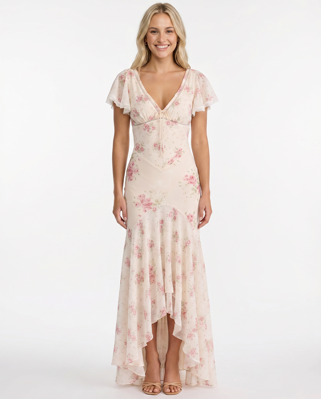 Female model in a flowing floral long dress on a plain background.