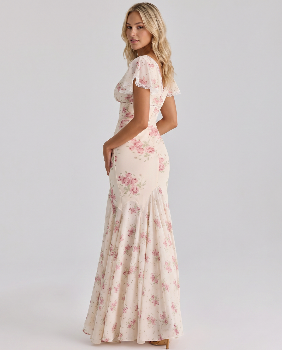 Model wearing a yellow floral maxi dress with cap sleeves on a plain background.