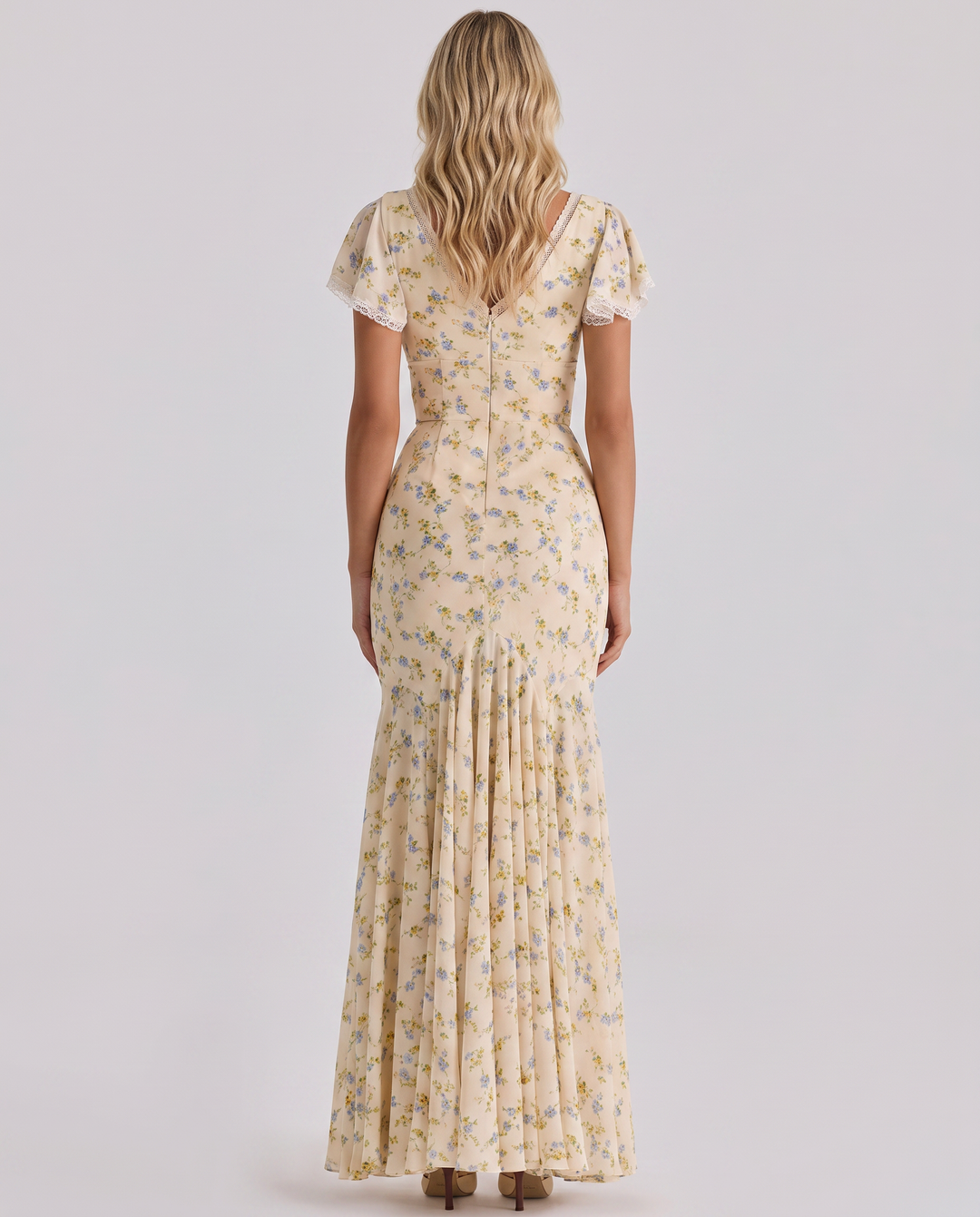 Model in a floral A-line maxi dress with lace trim on a plain background.