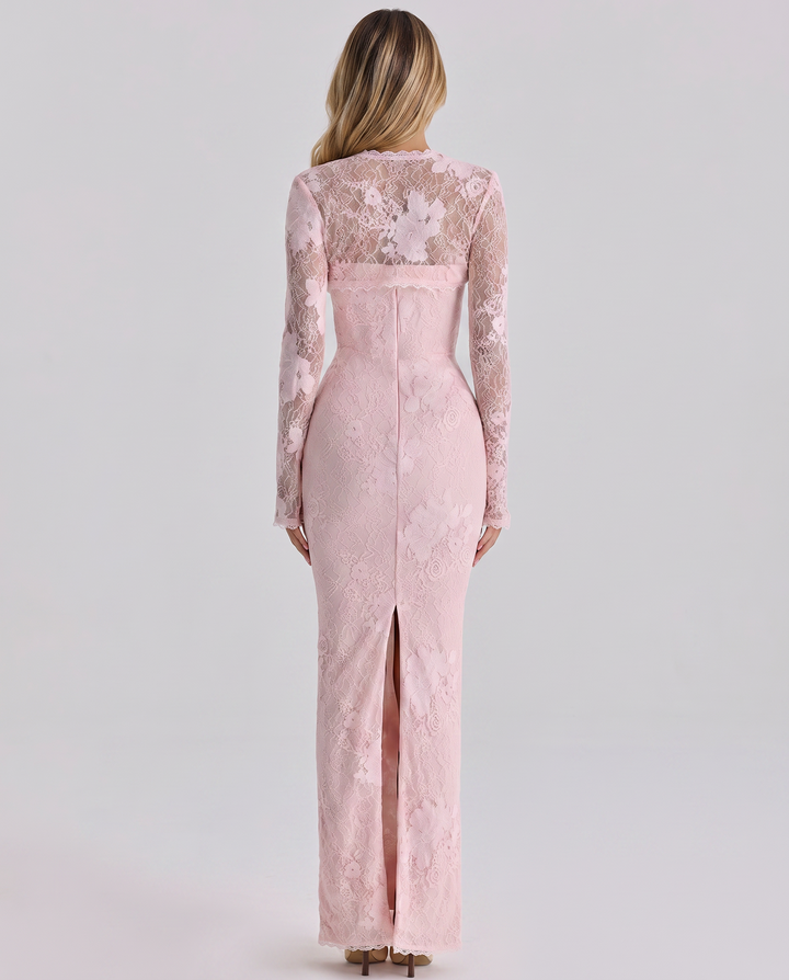 Woman in a full-length lace dress with a structured bodice against a plain background.