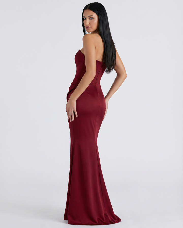 Female model wearing a formal strapless maxi dress on a plain background.