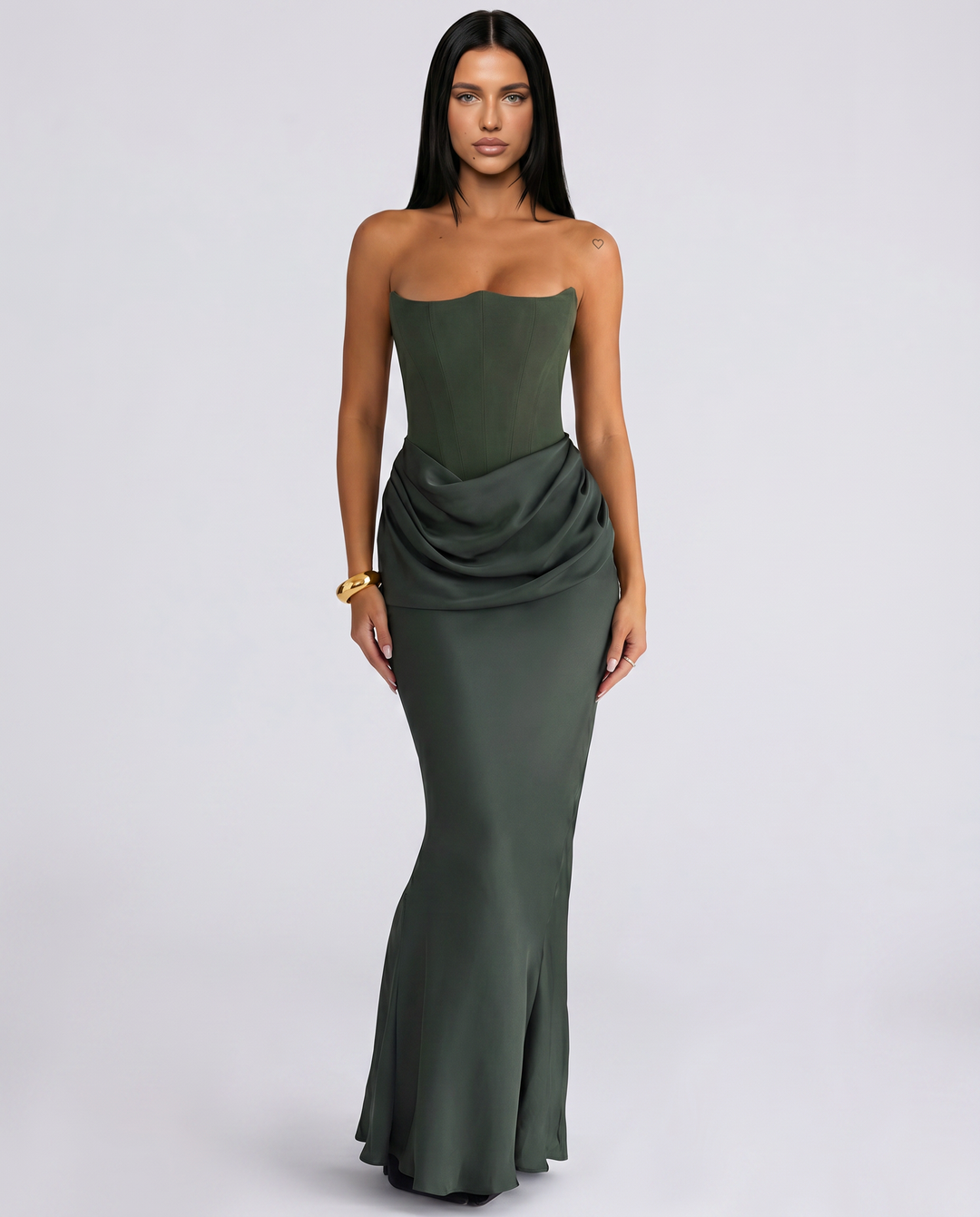Woman wearing a strapless maxi dress with a draped waist on a plain background.