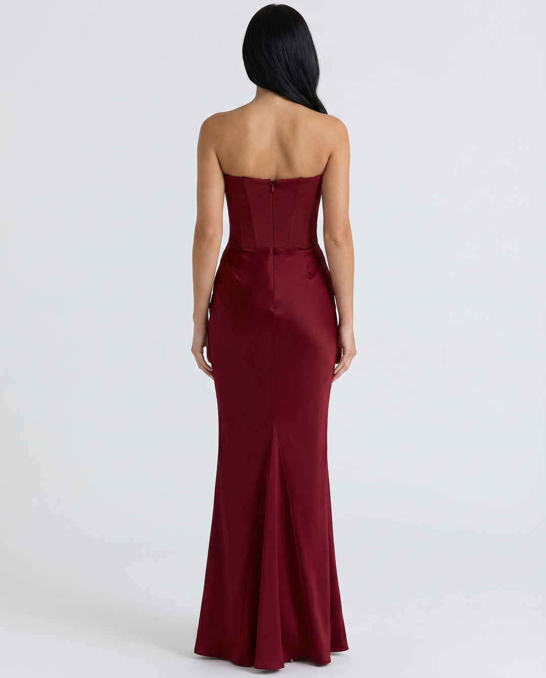 Female model wearing a sleek strapless gown with a softly gathered waist.