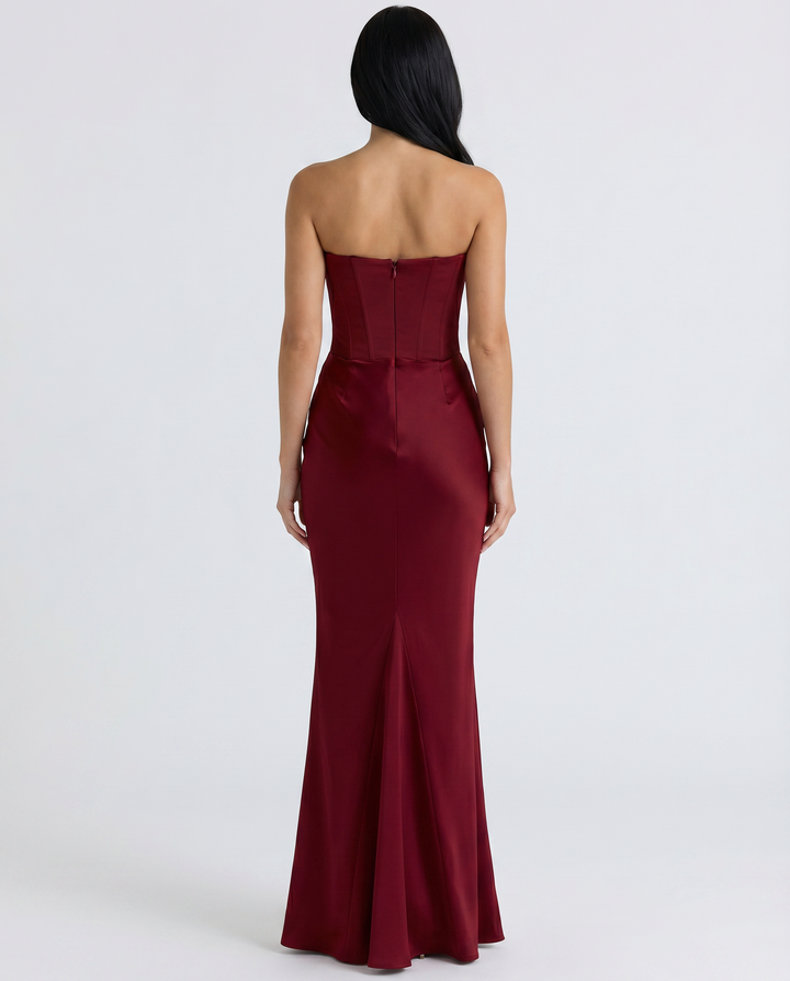 Female model wearing a sleek strapless gown with a softly gathered waist.
