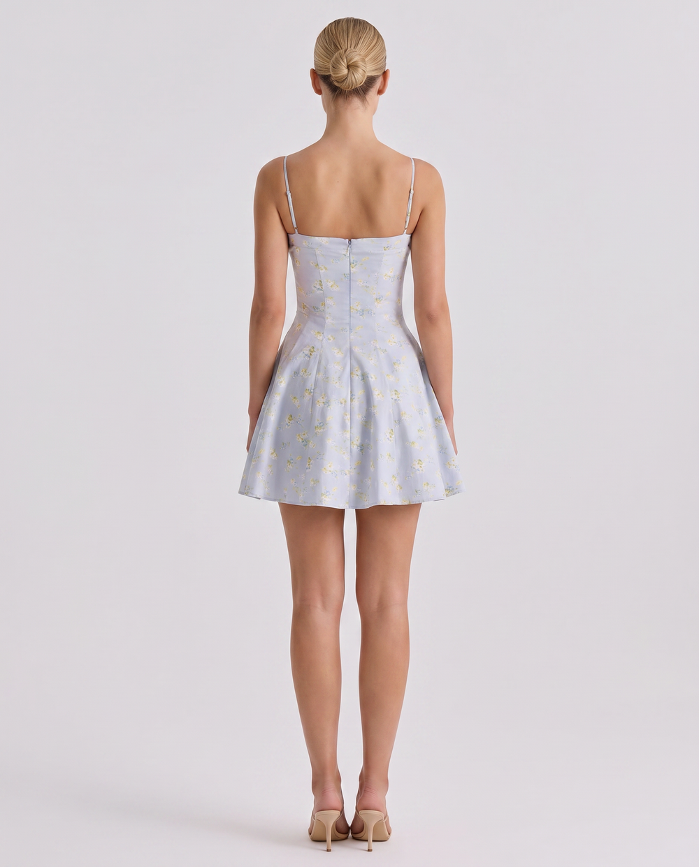 Woman modeling a lightweight sleeveless dress with a clean neckline on a plain background.