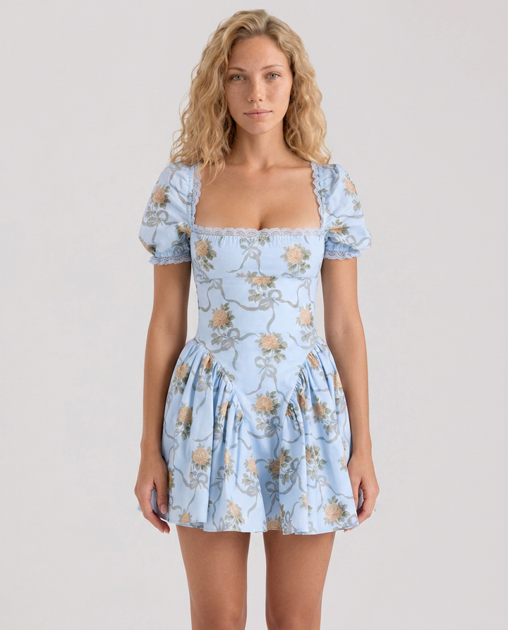 Woman wearing a blue floral mini dress with puff sleeves on a plain background.