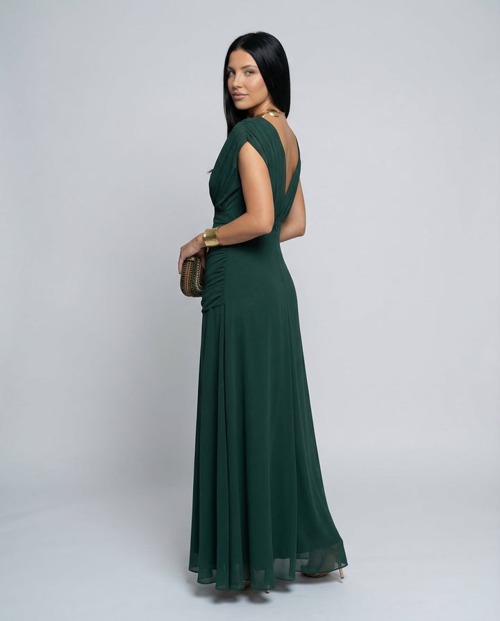 Female model in a long formal dress with polished styling on a plain background.