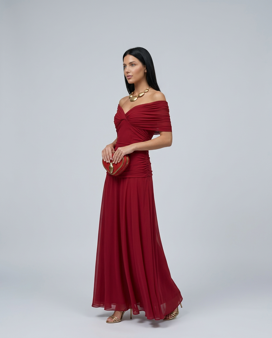 Woman showcasing a refined long dress with graceful drape on a plain background.
