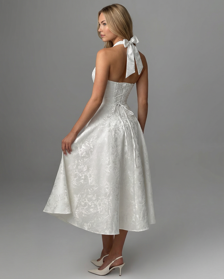 Female model displaying a sleeveless dress with a structured upper design on a plain background.