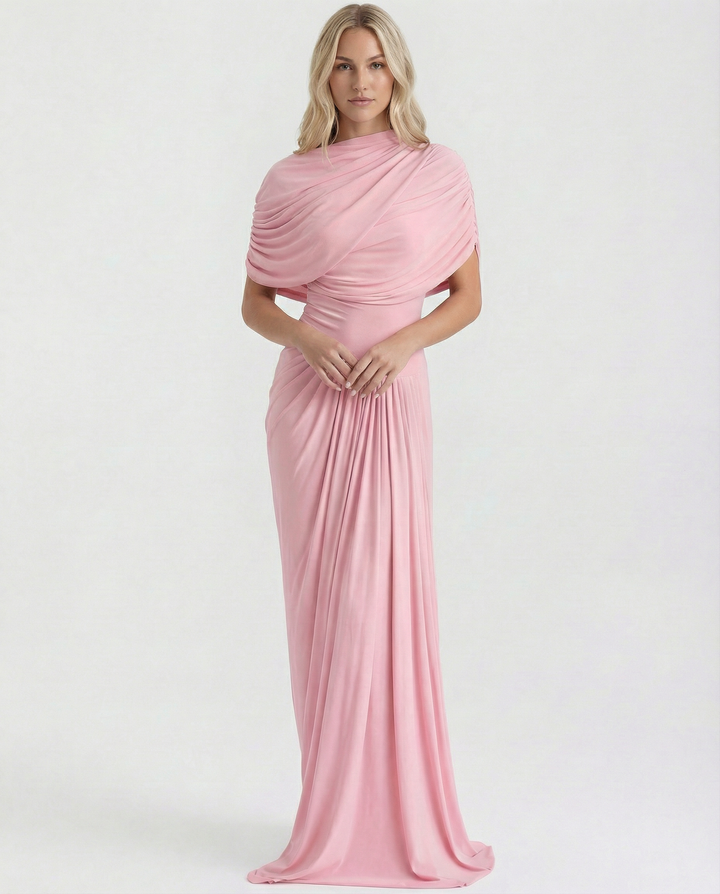 Female model in a pleated bodice occasion dress on a plain background.