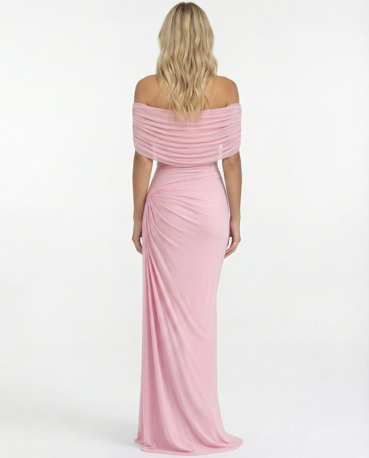 Woman wearing a flowing full-length event dress on a plain background.