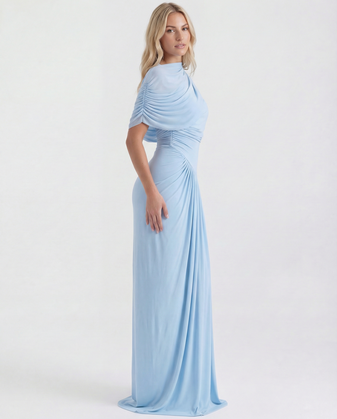 Female model wearing an elegant long dress with pleated bodice on a plain background.
