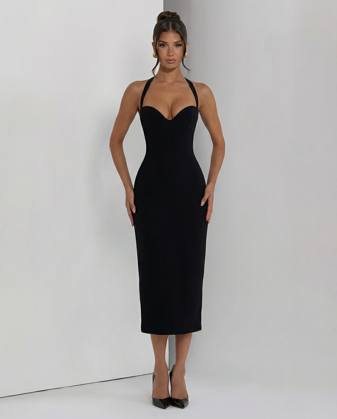 Woman in an elegant midi dress with a flowing hemline and soft neckline.