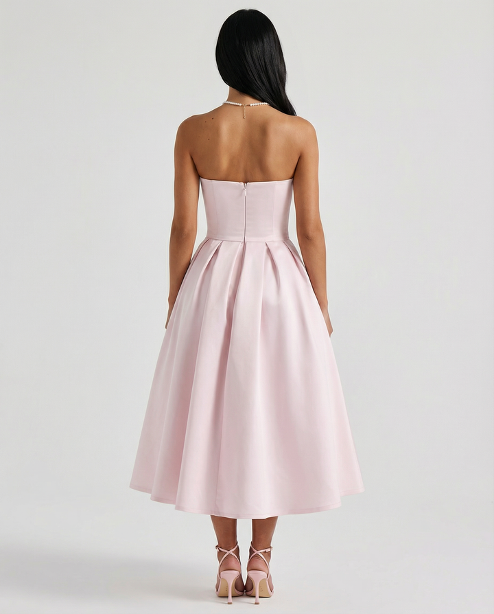 Woman wearing a poised celebration dress on a plain background.