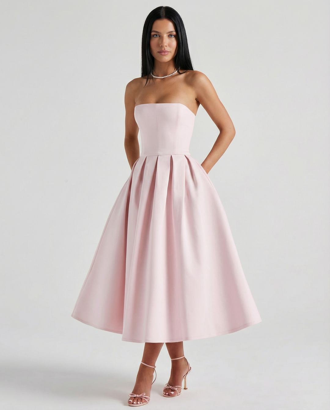 Model in a formal dress with a flowing skirt against a plain background.