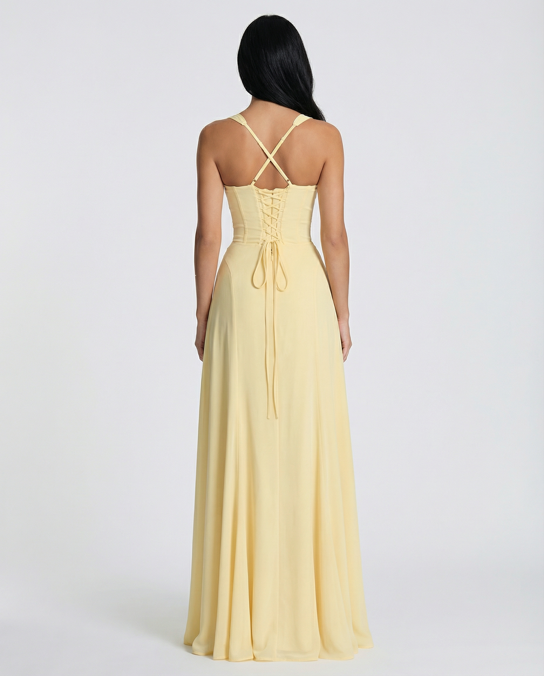 Woman in a sleeveless corset-style maxi dress with lace-up back on a plain background, back view