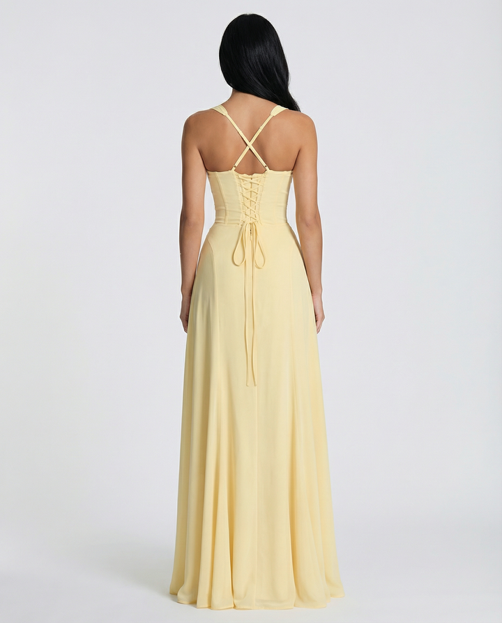 Woman in a sleeveless corset-style maxi dress with lace-up back on a plain background, back view