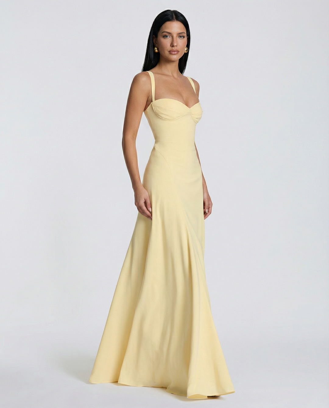 Model posing in a full-length fitted dress with floral detailing and slim straps.