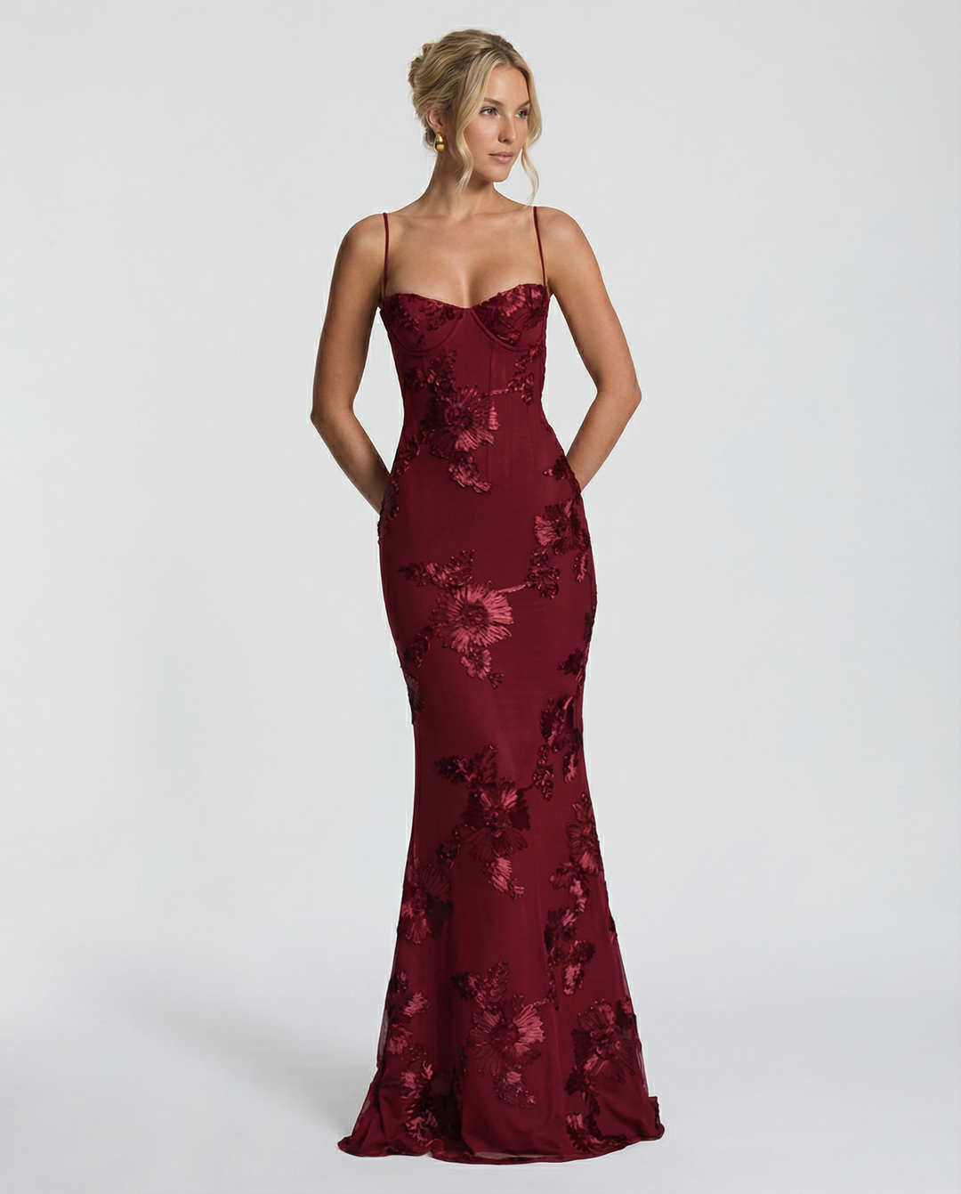 Model wearing a formal floral detail maxi dress with a sculpted silhouette.