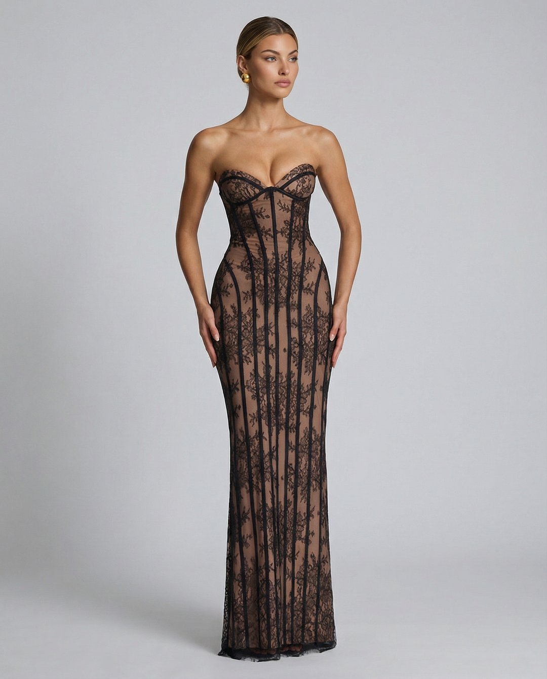 Woman wearing a full-length fitted dress with back split on a plain background.