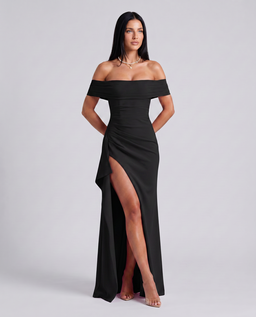 Female model in a fitted maxi dress with high side slit on a plain background.