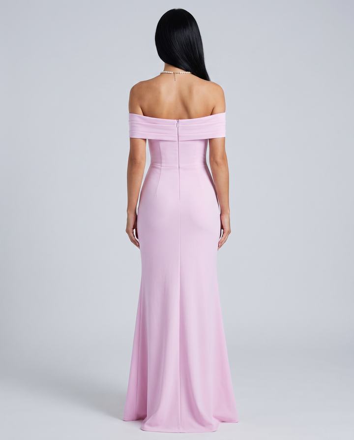 Woman in a sleeveless bodycon maxi dress with side slit on a plain background.