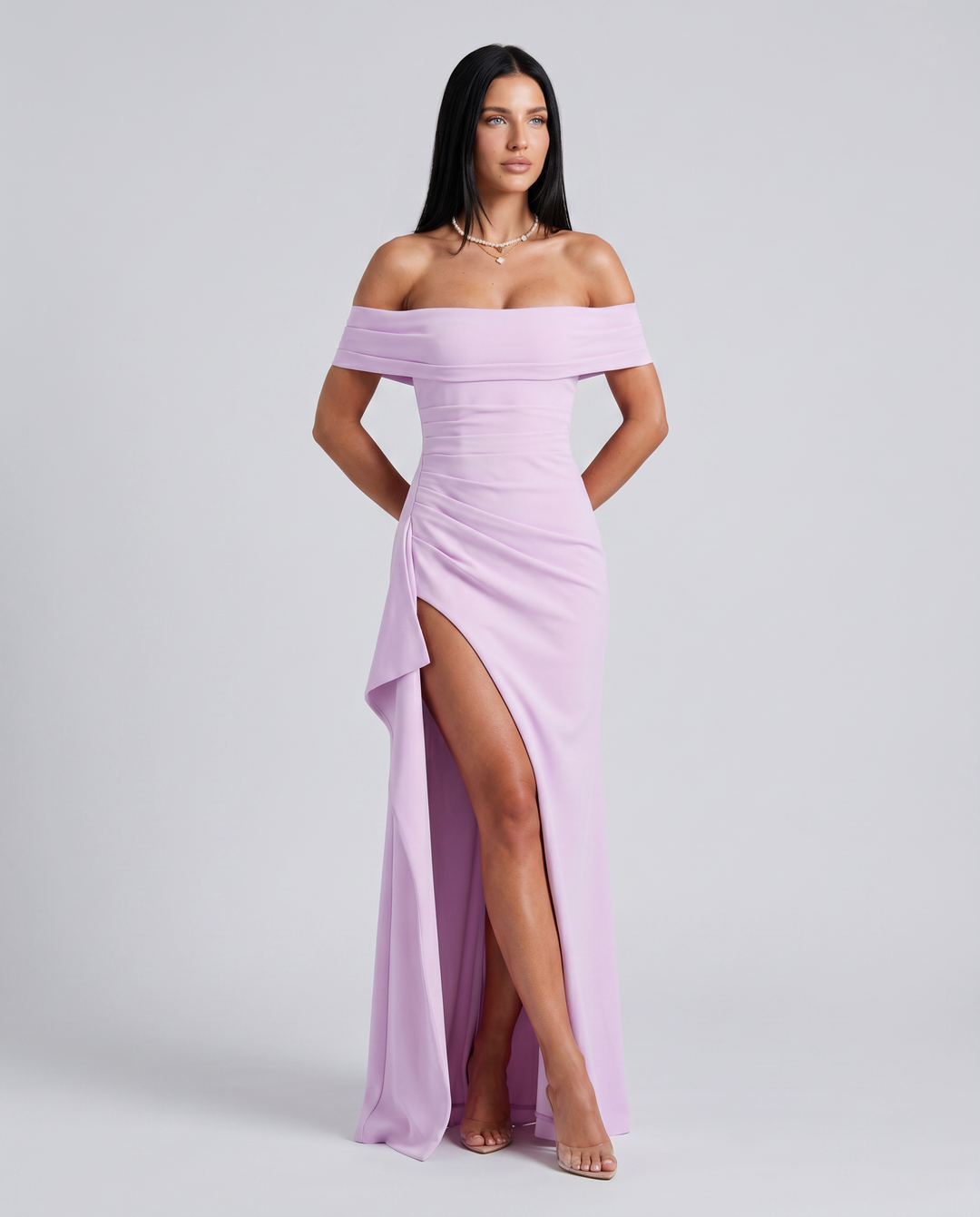 emale model wearing an off shoulder fitted maxi dress on a plain background.