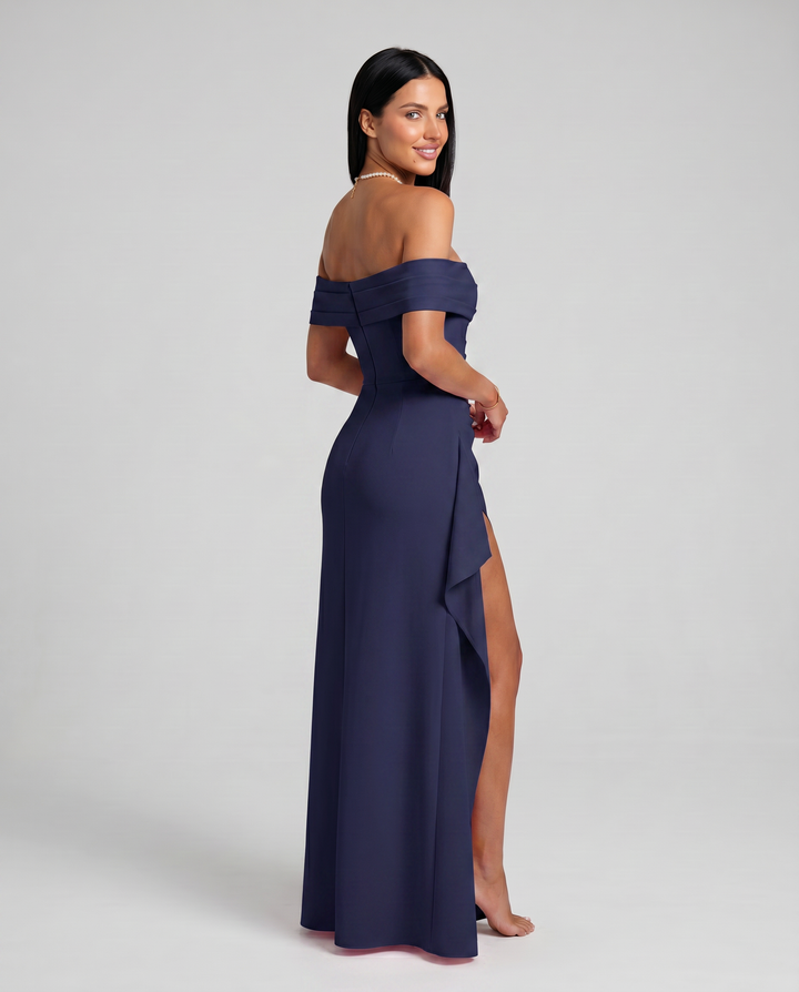 Female model in a formal bodycon dress with side slit on a plain background.