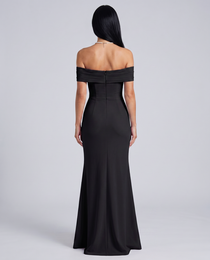 Woman styled in a sleek sleeveless evening dress on a plain background.