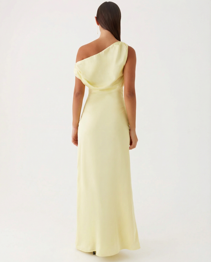 Female model in a full-length one-shoulder dress on a plain background.